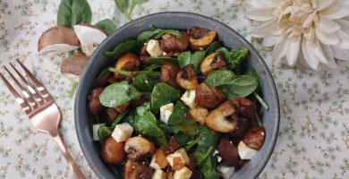 Ensalada vegetariana y templada con brotes de espinacas y champiñones